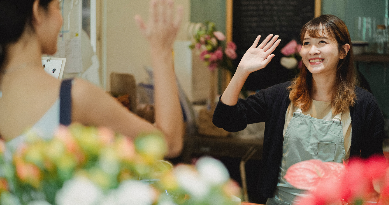 Smiling cashier and customer doing a high-five.