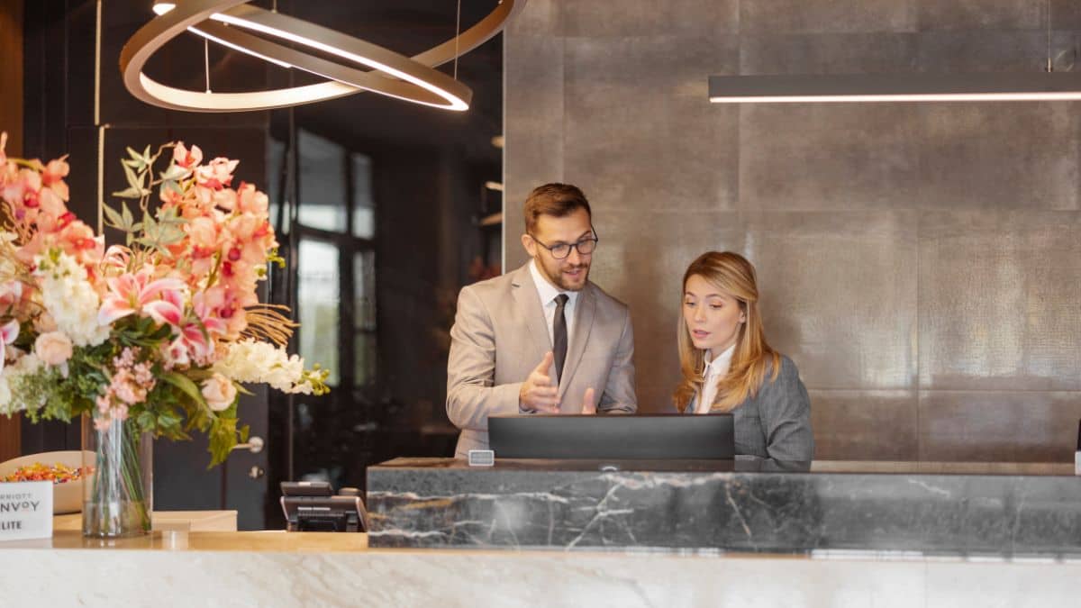 Male and Female hotel personal staring at computer